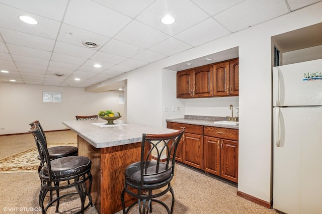 9228 S 55th Ct, Oak Lawn, IL 60453 - kitchen with freestanding refrigerator, a breakfast bar area, a kitchen island, light countertops, and light carpet