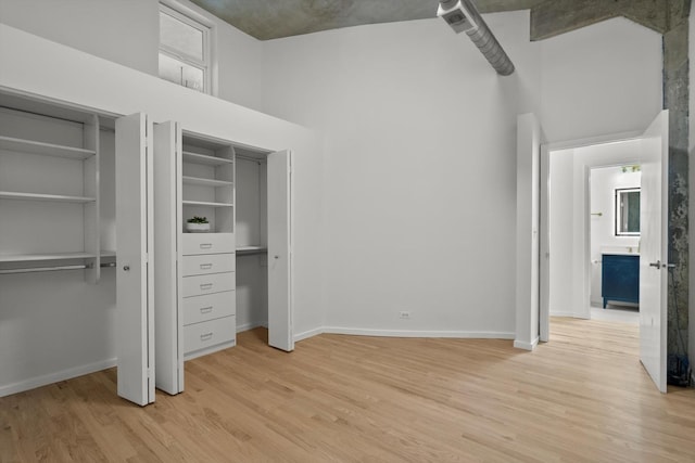 817 W Washington Blvd Unit 503, Chicago, IL 60607 - unfurnished bedroom with two closets, light wood-style flooring, and a high ceiling
