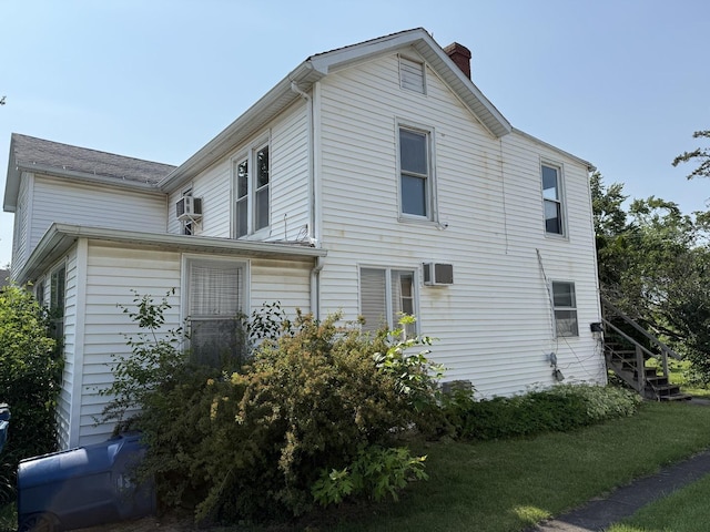 112 W Chippewa St, Dwight, IL 60420 - view of home's exterior with a chimney, an AC wall unit, and stairs