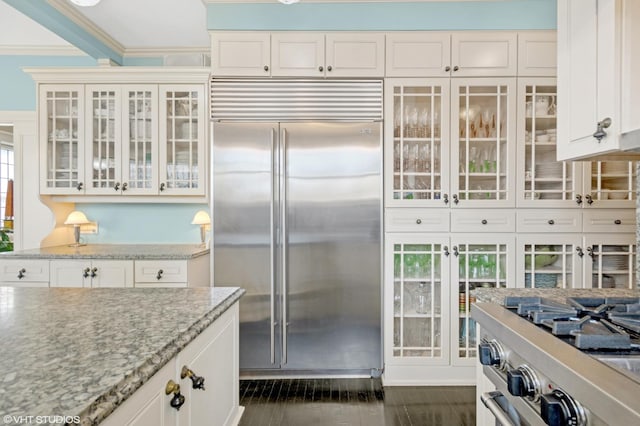 1116 W N Shore Ave Unit 2, Chicago, IL 60626 - kitchen featuring built in fridge, crown molding, light stone counters, white cabinets, and glass insert cabinets
