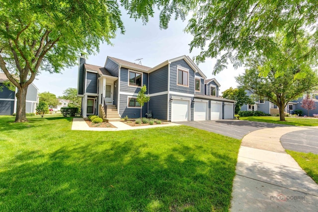 923 Manchester Cir Unit 923, Schaumburg, IL 60193 - view of front of property featuring driveway, an attached garage, a front lawn, and a chimney