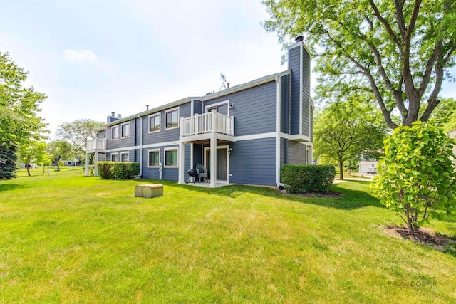 923 Manchester Cir Unit 923, Schaumburg, IL 60193 - rear view of house featuring a chimney, a yard, and a balcony