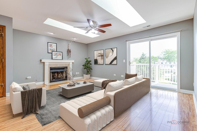 923 Manchester Cir Unit 923, Schaumburg, IL 60193 - living area featuring a skylight, light wood-style flooring, a premium fireplace, and a ceiling fan
