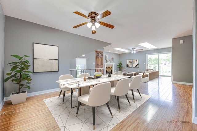 923 Manchester Cir Unit 923, Schaumburg, IL 60193 - dining space with ceiling fan, light wood-style floors, and a skylight