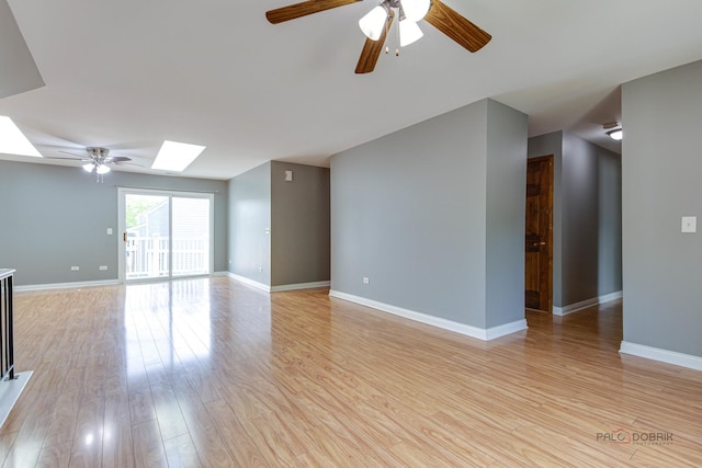 923 Manchester Cir Unit 923, Schaumburg, IL 60193 - unfurnished living room featuring a skylight, a ceiling fan, and light wood-style floors