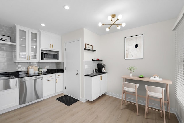 14449 Golf Rd, Orland Park, IL 60462 - kitchen featuring appliances with stainless steel finishes, backsplash, light wood-style flooring, white cabinets, and glass insert cabinets