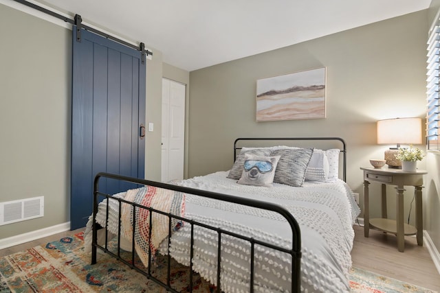 661 Regal Ln, Algonquin, IL 60102 - bedroom featuring a barn door and wood finished floors
