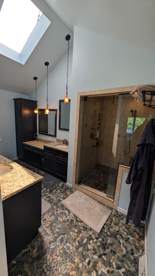 5N119 Mary Ct, Saint Charles, IL 60175 - bathroom with a skylight, two vanities, a stall shower, and high vaulted ceiling