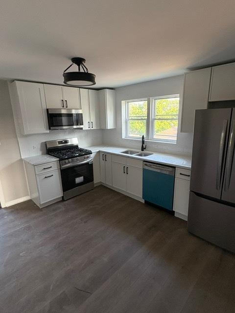1405 N 24th Ave, Melrose Park, IL 60160 - kitchen featuring appliances with stainless steel finishes, light countertops, dark wood-type flooring, and white cabinets