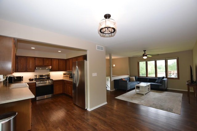 1116 Oakleaf Ave, Mchenry, IL 60051 - kitchen featuring stainless steel appliances, under cabinet range hood, light countertops, open floor plan, and dark wood-type flooring