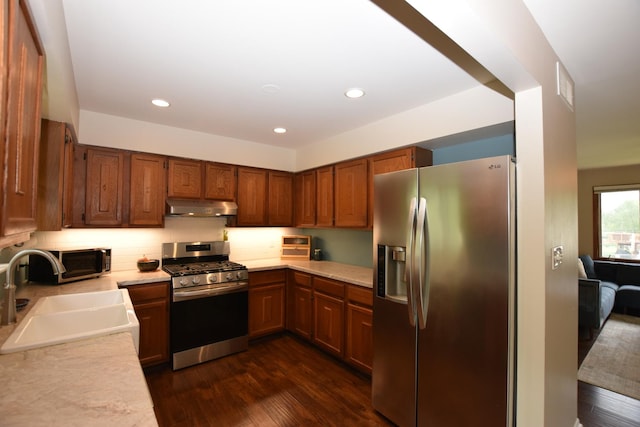 1116 Oakleaf Ave, Mchenry, IL 60051 - kitchen with stainless steel appliances, under cabinet range hood, light countertops, brown cabinetry, and dark wood-style floors