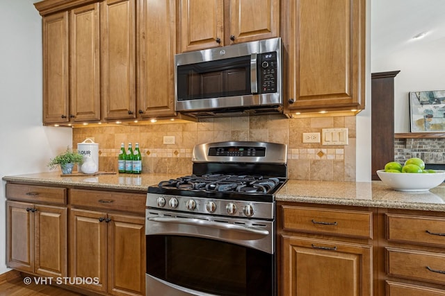 4120 Idlewild Ln, Naperville, IL 60564 - kitchen with appliances with stainless steel finishes, brown cabinetry, light stone counters, and tasteful backsplash