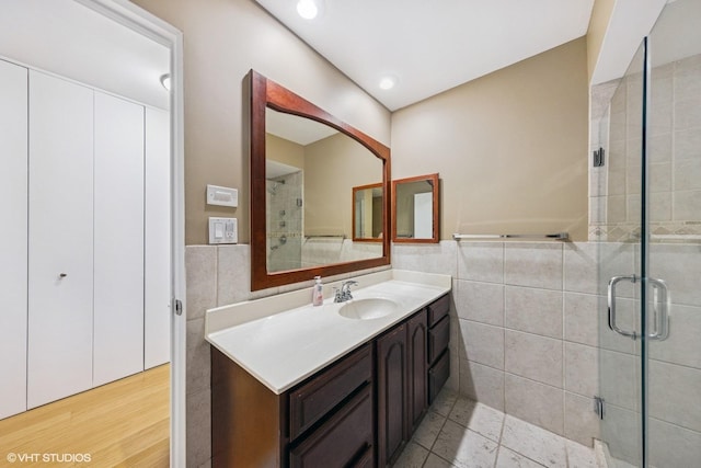 340 Claymoor Rd Unit 2B, Hinsdale, IL 60521 - bathroom with tile walls, vanity, a shower stall, and a wainscoted wall
