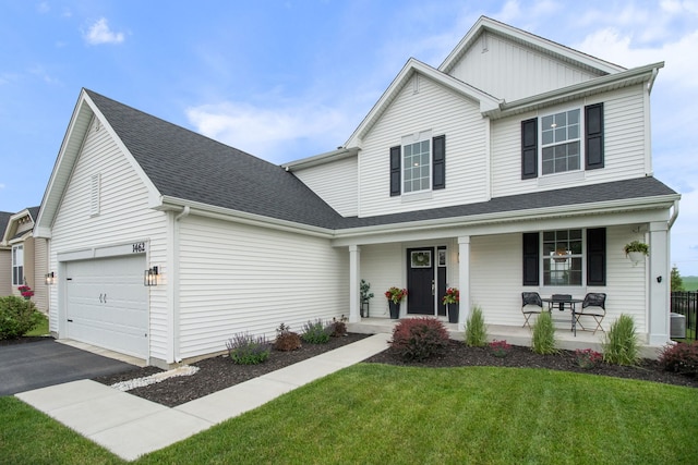 1462 Keller St, Elburn, IL 60119 - traditional-style home with covered porch, asphalt driveway, a front lawn, an attached garage, and board and batten siding