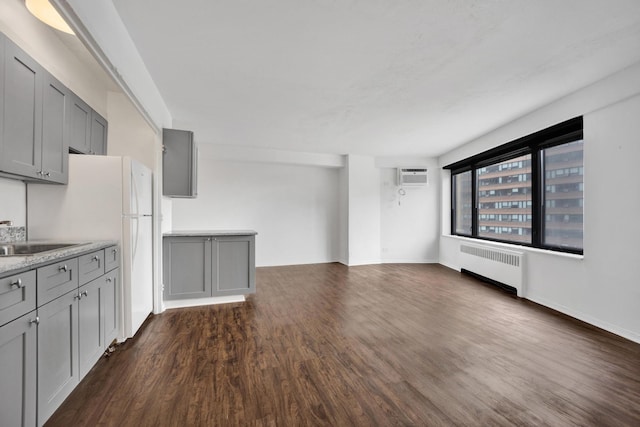 3100 N Lake Shore Dr Unit 413, Chicago, IL 60657 - unfurnished living room with radiator heating unit, a wall mounted AC, and dark wood-style floors