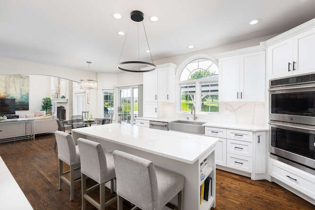 3527 Scottsdale Cir, Naperville, IL 60564 - kitchen with stainless steel appliances, a kitchen breakfast bar, recessed lighting, white cabinets, and a center island