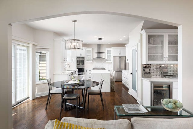 3527 Scottsdale Cir, Naperville, IL 60564 - dining room with wine cooler, dark wood finished floors, a chandelier, arched walkways, and recessed lighting