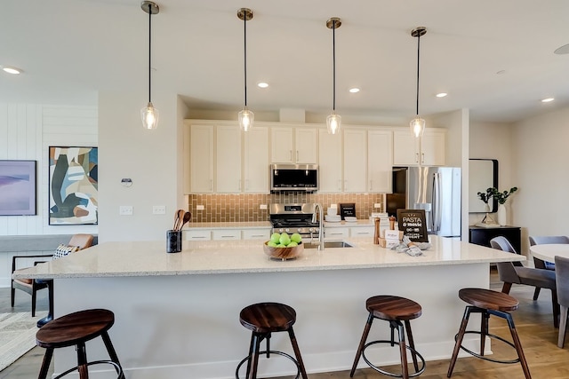 1058 E Oakton St, Des Plaines, IL 60018 - kitchen with appliances with stainless steel finishes, a kitchen breakfast bar, decorative backsplash, a large island with sink, and white cabinets