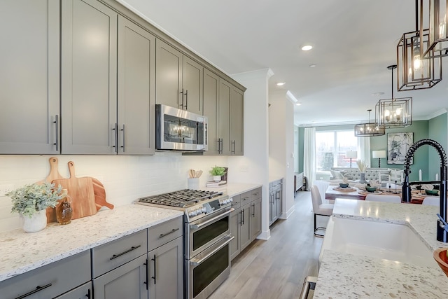 1060 E Oakton St, Des Plaines, IL 60018 - kitchen with appliances with stainless steel finishes, gray cabinets, decorative backsplash, a chandelier, and ornamental molding