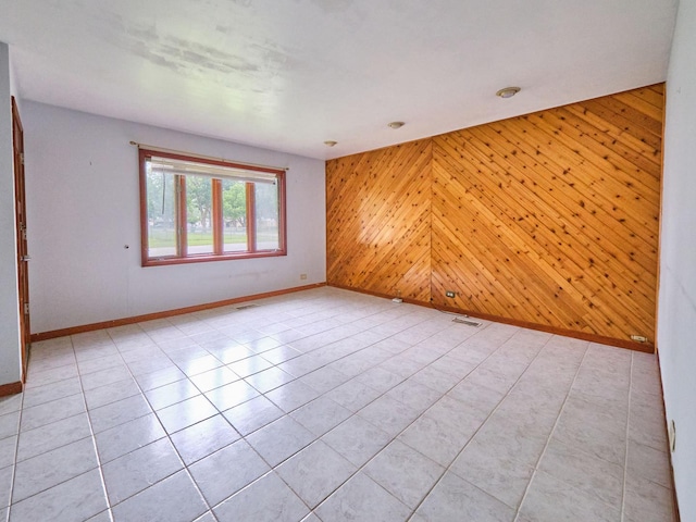 109 George Rd, Wheeling, IL 60090 - empty room with an accent wall, wood walls, and light tile patterned floors