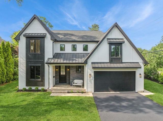900 Pleasant Ln, Glenview, IL 60025 - modern farmhouse featuring a standing seam roof, covered porch, asphalt driveway, a front yard, and an attached garage