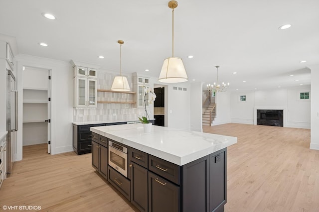 900 Pleasant Ln, Glenview, IL 60025 - kitchen with stainless steel microwave, light wood-style floors, open shelves, tasteful backsplash, and recessed lighting