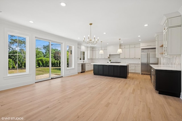 900 Pleasant Ln, Glenview, IL 60025 - kitchen featuring stainless steel appliances, light countertops, a chandelier, decorative backsplash, and light wood-style floors
