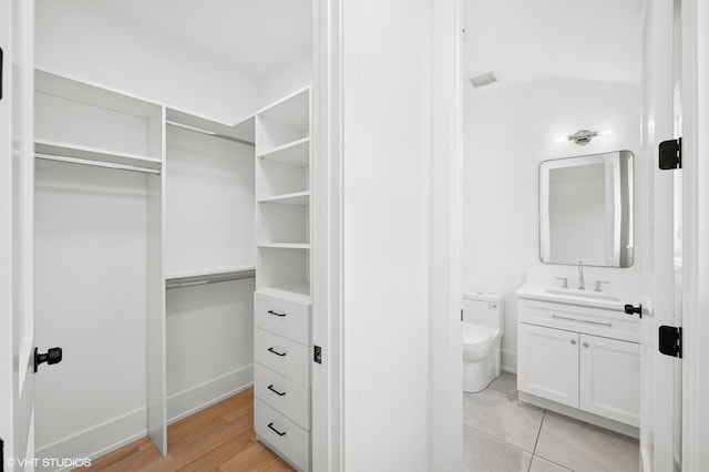 900 Pleasant Ln, Glenview, IL 60025 - bathroom featuring vanity, a walk in closet, and wood finished floors