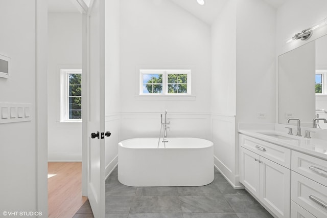 900 Pleasant Ln, Glenview, IL 60025 - bathroom with healthy amount of natural light, vanity, a freestanding bath, high vaulted ceiling, and a wainscoted wall
