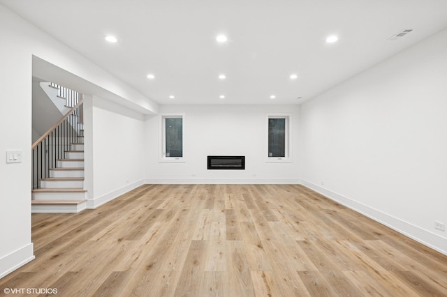 900 Pleasant Ln, Glenview, IL 60025 - unfurnished living room featuring light wood-type flooring, stairs, recessed lighting, and a glass covered fireplace