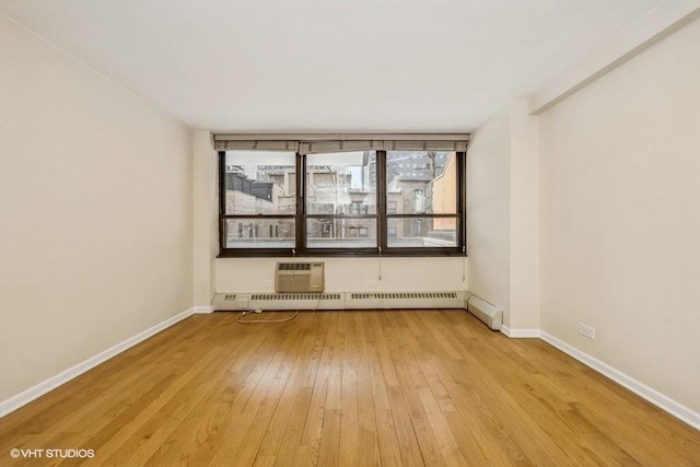 33 E Cedar St Unit 3D, Chicago, IL 60611 - unfurnished room with a baseboard heating unit, light wood-style floors, and a wall unit AC