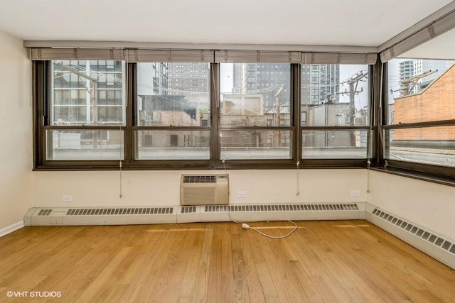 33 E Cedar St Unit 3D, Chicago, IL 60611 - spare room with wood finished floors, a wall mounted AC, and plenty of natural light