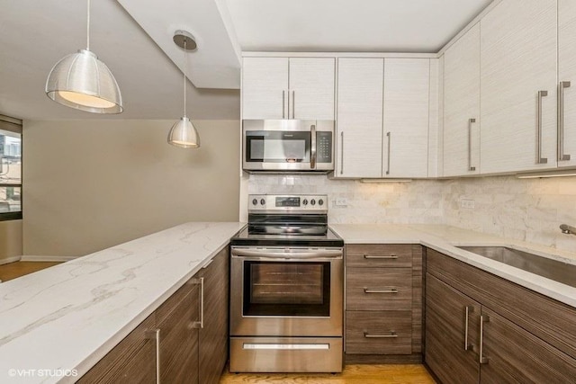 33 E Cedar St Unit 3D, Chicago, IL 60611 - kitchen with appliances with stainless steel finishes, tasteful backsplash, decorative light fixtures, light stone counters, and white cabinetry
