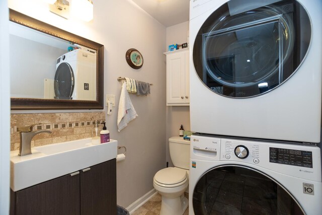 9201 Drake Ave Unit 101S, Evanston, IL 60203 - bathroom featuring stacked washer and clothes dryer, vanity, tile patterned flooring, and tasteful backsplash