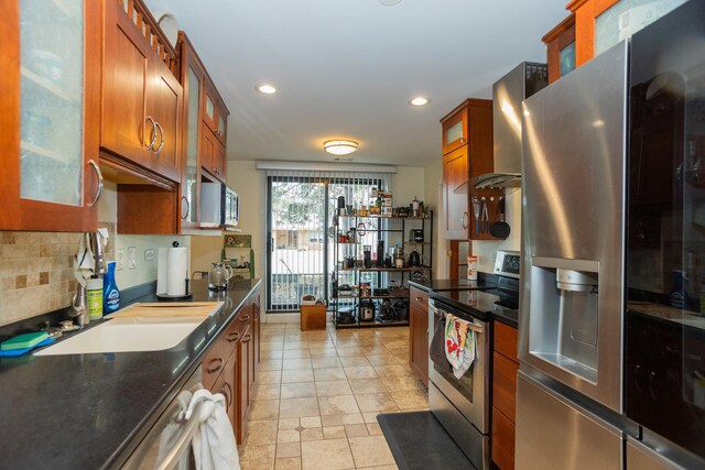 9201 Drake Ave Unit 101S, Evanston, IL 60203 - kitchen featuring stainless steel appliances, wall chimney exhaust hood, glass insert cabinets, brown cabinets, and recessed lighting
