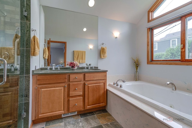 908 Jackson Ave, Wauconda, IL 60084 - bathroom with a tub with jets, double vanity, a stall shower, vaulted ceiling, and stone finish floors