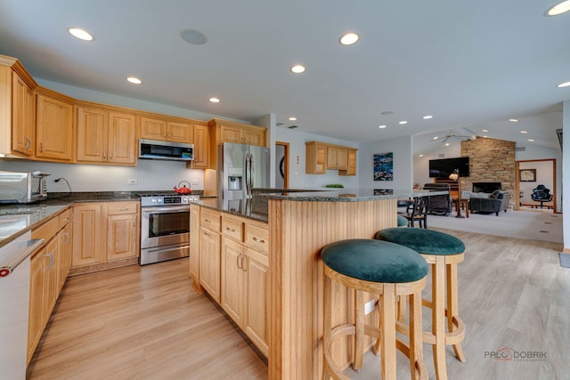 908 Jackson Ave, Wauconda, IL 60084 - kitchen featuring stainless steel appliances, a breakfast bar, open floor plan, light wood-type flooring, and recessed lighting