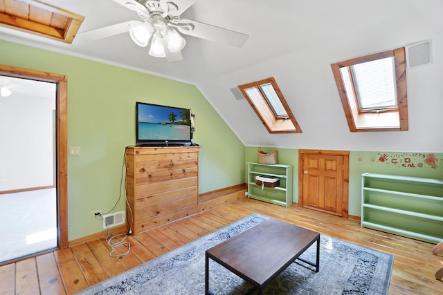 24 Robin Crest Rd, Hawthorn Woods, IL 60047 - living area featuring a skylight, light wood-style flooring, ceiling fan, vaulted ceiling, and healthy amount of natural light