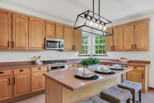 34405 N Bobolink Trl, Grayslake, IL 60030 - kitchen featuring appliances with stainless steel finishes, a breakfast bar, light tile patterned floors, and a kitchen island