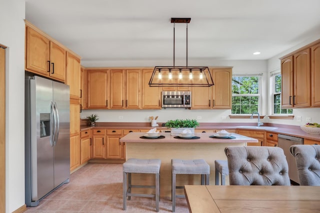 34405 N Bobolink Trl, Grayslake, IL 60030 - kitchen featuring stainless steel appliances, a breakfast bar, light countertops, pendant lighting, and a center island