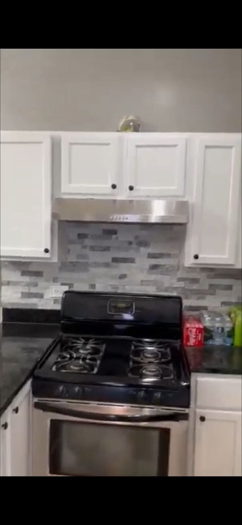 4226 W Ogden, Chicago, IL 60623 - kitchen featuring stainless steel range with gas cooktop, white cabinetry, dark countertops, and backsplash