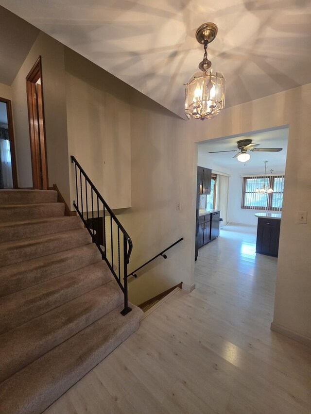 7725 Sawyer Rd, Darien, IL 60561 - stairway featuring a chandelier, wood finished floors, a ceiling fan, and vaulted ceiling