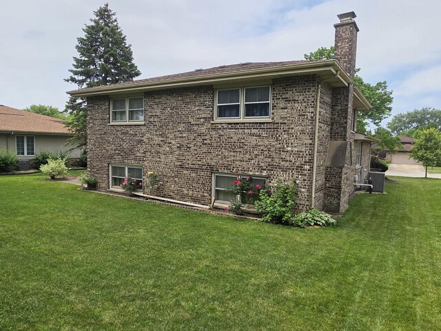 7725 Sawyer Rd, Darien, IL 60561 - view of home's exterior with a chimney, a lawn, and brick siding
