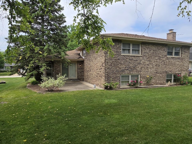 7725 Sawyer Rd, Darien, IL 60561 - view of front of house with a patio, a front lawn, a chimney, and brick siding