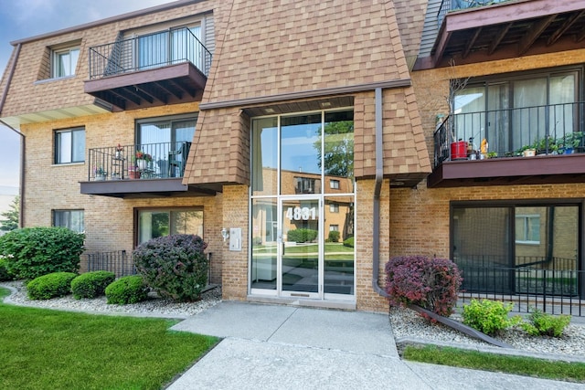 4831 W 109th St Unit 101, Oak Lawn, IL 60453 - view of exterior entry with a balcony, brick siding, and a shingled roof