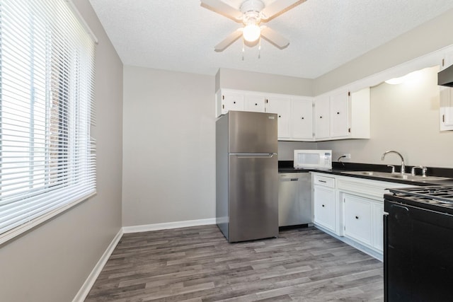 4831 W 109th St Unit 101, Oak Lawn, IL 60453 - kitchen with appliances with stainless steel finishes, light wood-style flooring, ceiling fan, white cabinetry, and dark countertops