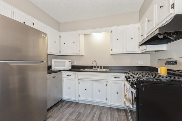 4831 W 109th St Unit 101, Oak Lawn, IL 60453 - kitchen with appliances with stainless steel finishes, under cabinet range hood, dark countertops, white cabinets, and a textured ceiling