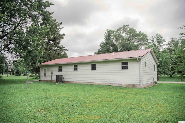 107 N First St, West Point, IL 62380 - rear view of house with a lawn, crawl space, a metal roof, and view of wooded area