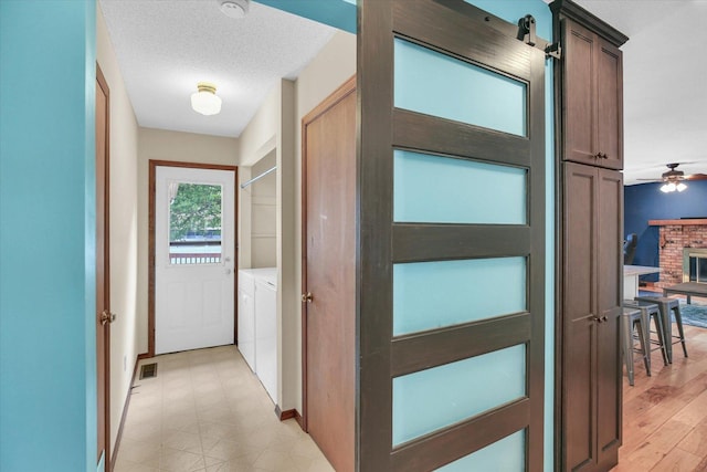 3204 Fawn Hill Ct, Urbana, IL 61802 - doorway to outside featuring washer and dryer, a ceiling fan, and a brick fireplace