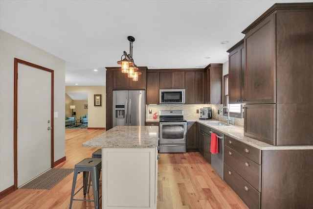 3204 Fawn Hill Ct, Urbana, IL 61802 - kitchen featuring appliances with stainless steel finishes, light wood finished floors, dark brown cabinets, light stone counters, and recessed lighting